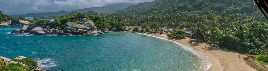 Tayrona National Park holidays - view of gorgeous sandy bay and rainforest backdrop